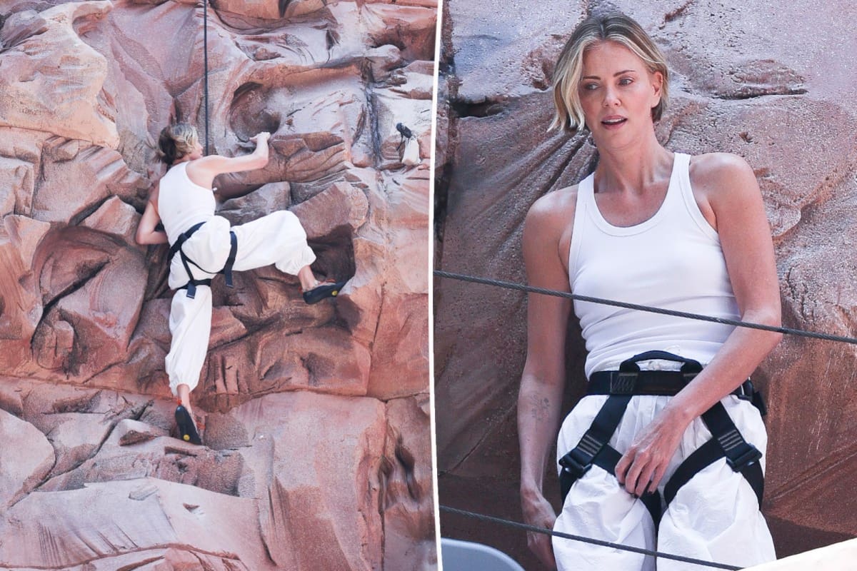 Charlize Theron escalando un muro de piedra para promocionar 'Apex' en Times Square, el pasado 24 de abril de 2026.