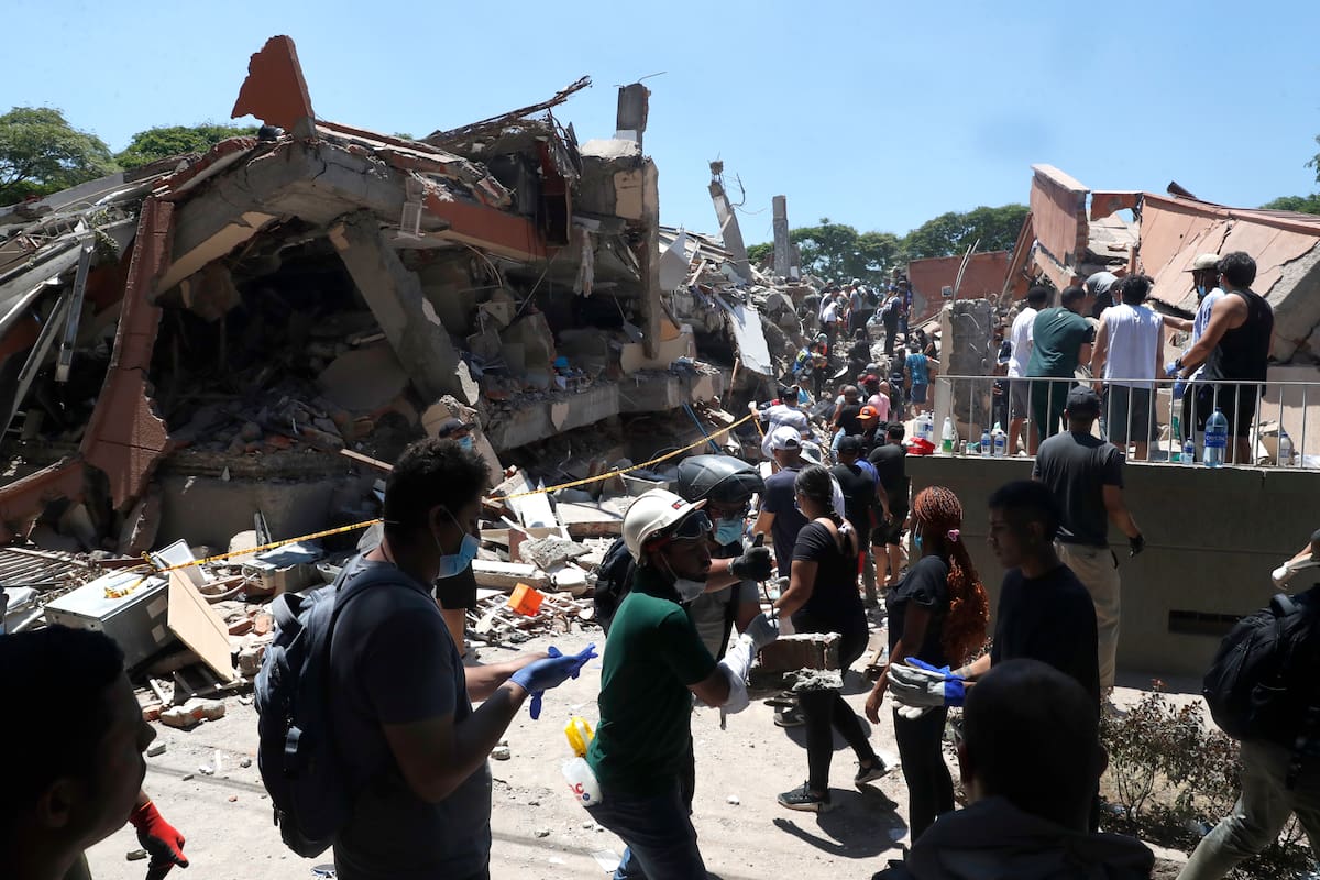 Integrantes del cuerpo de Bomberos de Cali y civiles buscan entre los escombros de edificaciones colapsadas por el terremoto de magnitud 7,4 que sacudió esta mañana el país, este lunes en Cali (Colombia). El Gobierno colombiano declaró la situación de "desastre nacional" por el terremoto que deja al menos 71 personas fallecidas en el país, 29 de ellas en ciudades capitales. EFE/ Ernesto Guzmán Jr