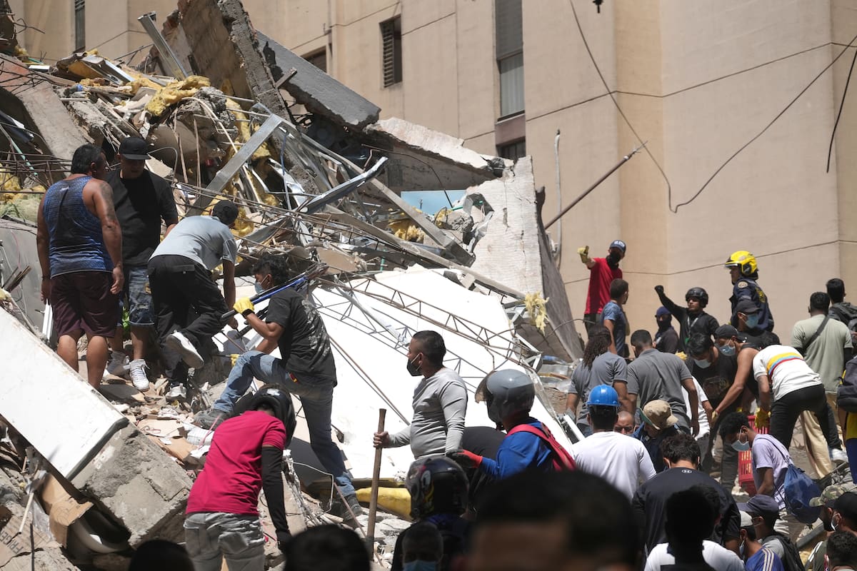 Integrantes del cuerpo de Bomberos de Cali y civiles buscan entre los escombros de edificaciones colapsadas por el terremoto de magnitud 7,4 que sacudió esta mañana el país, este lunes en Cali (Colombia). El Gobierno colombiano declaró la situación de "desastre nacional" por el terremoto que deja al menos 71 personas fallecidas en el país, 29 de ellas en ciudades capitales. EFE/ Ernesto Guzmán Jr