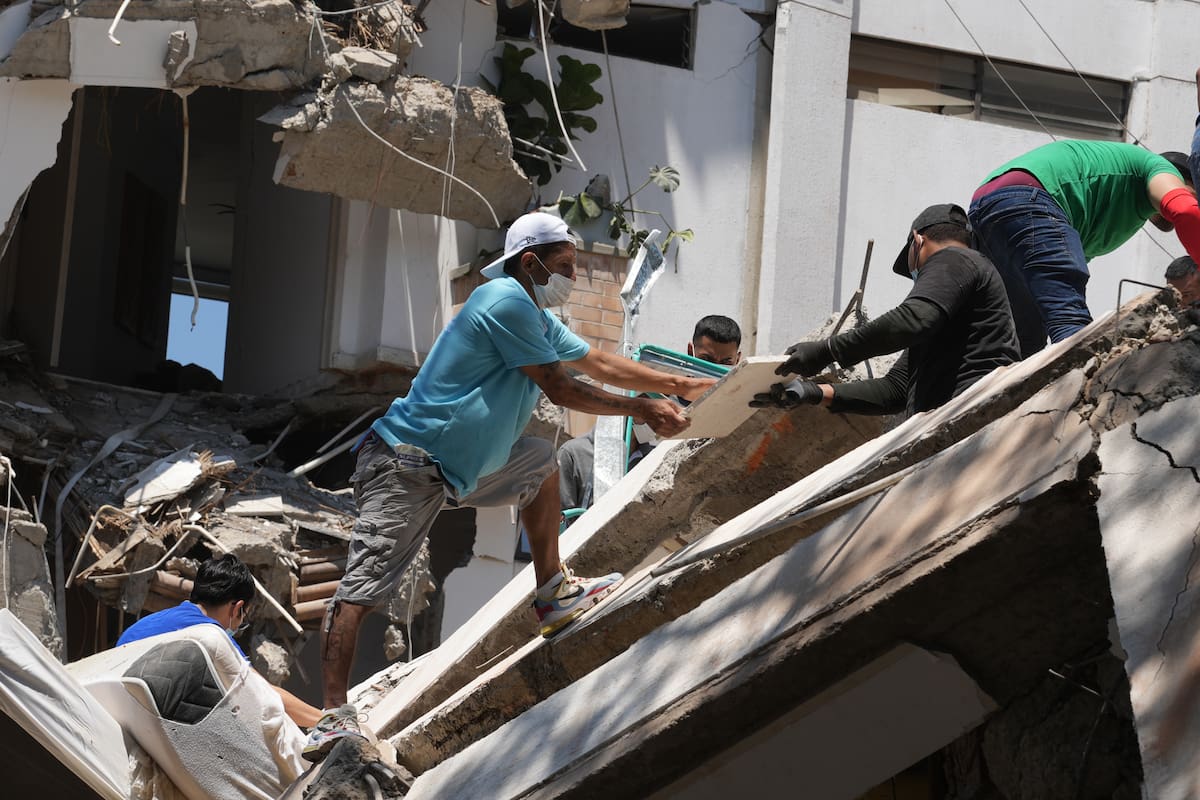 AME7690. CALI (COLOMBIA), 10/08/2026.- Integrantes del cuerpo de Bomberos de Cali y civiles buscan entre los escombros de edificaciones colapsadas por el terremoto de magnitud 7,4 que sacudió esta mañana el país, este lunes en Cali (Colombia). El Gobierno colombiano declaró la situación de "desastre nacional" por el terremoto que deja al menos 71 personas fallecidas en el país, 29 de ellas en ciudades capitales. EFE/ Ernesto Guzmán Jr
