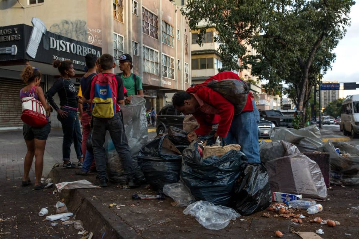 Unas 70 personas -incluidos varios niños- esperan los carros recolectores y se reparten el control de la basura de restaurantes. (Foto: AFP/VANGUARDIA LIBERAL )