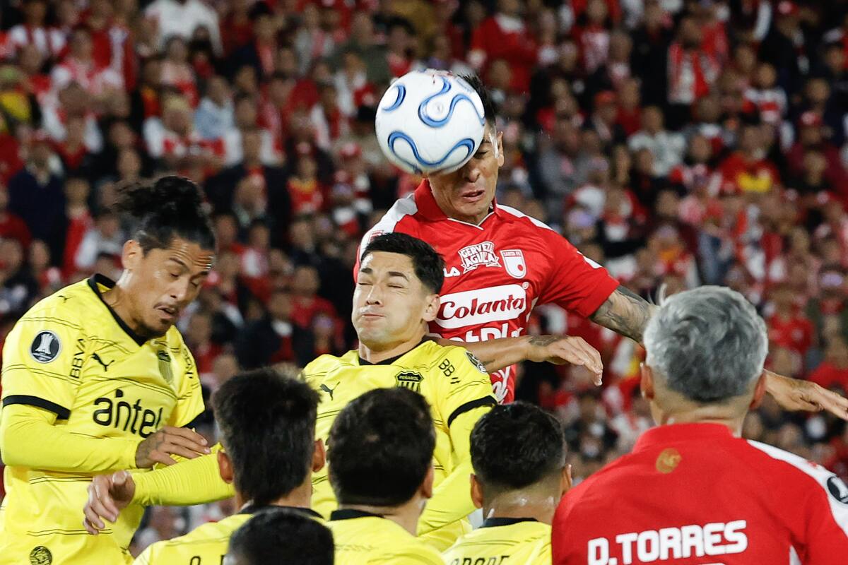 AME1994. BOGOTÁ (COLOMBIA), 09/04/2026.- Emmanuel Olivera (c) de Santa Fe cabecea el balón este jueves, en un partido de la fase de grupos de la Copa Libertadores entre Independiente Santa Fe y Peñarol este jueves, en el estadio El Campín, en Bogotá (Colombia). EFE/ Mauricio Dueñas Castañeda