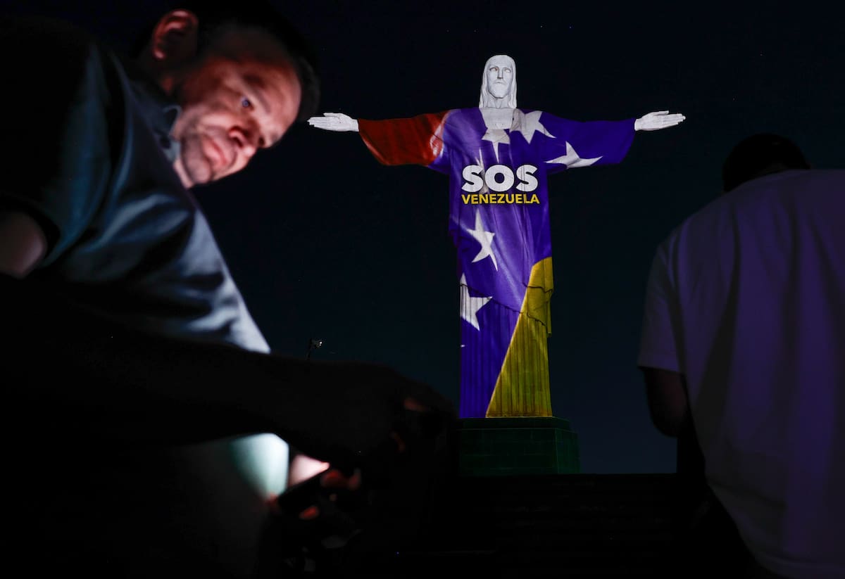Personas observan el monumento al Cristo Redentor este jueves, con una proyección en homenaje a las víctimas de los terremotos que azotaron a Venezuela la semana pasada, en Río de Janeiro (Brasil). EFE/André Coelho