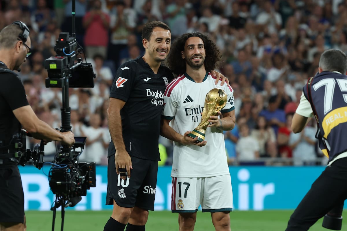 El defensa del Real Madrid Marc Cucurella (d) y el delantero de la Real Sociedad Mikel Oyarzabal posan con la Copa del Mundo conquistada por el equipo nacional este verano en Nueva York, antes del inicio del encuentro correspondiente a la primera jornada de LaLiga que Real Madrid y Real Sociedad disputan este miércoles en el Santiago Bernabéu, en Madrid. EFE/Kiko Huesca