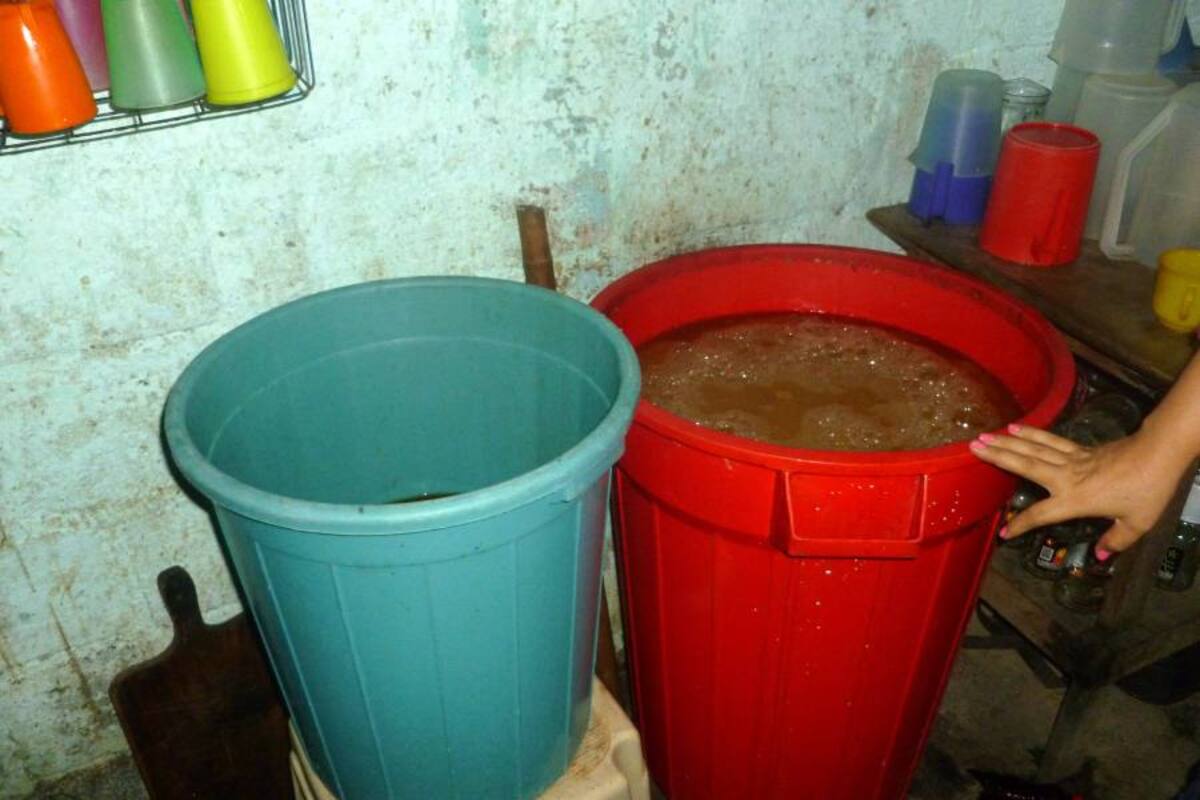 Luego de hacer el decomiso del ‘guarapo’, funcionarios de la Secretaría Local de Salud botaron la bebida por un desagüe, en presencia de los responsables de la producción. (Foto: Suministrada/VANGUARDIA LIBERAL)