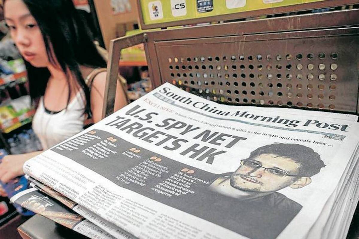 Una mujer camina en Hong Kong al lado de una edición del diario South China Morning, donde aparece en su portada una entrevista al exagente estadounidense Edward Snowden. (Foto: AFP / VANGUARDIA LIBERAL)