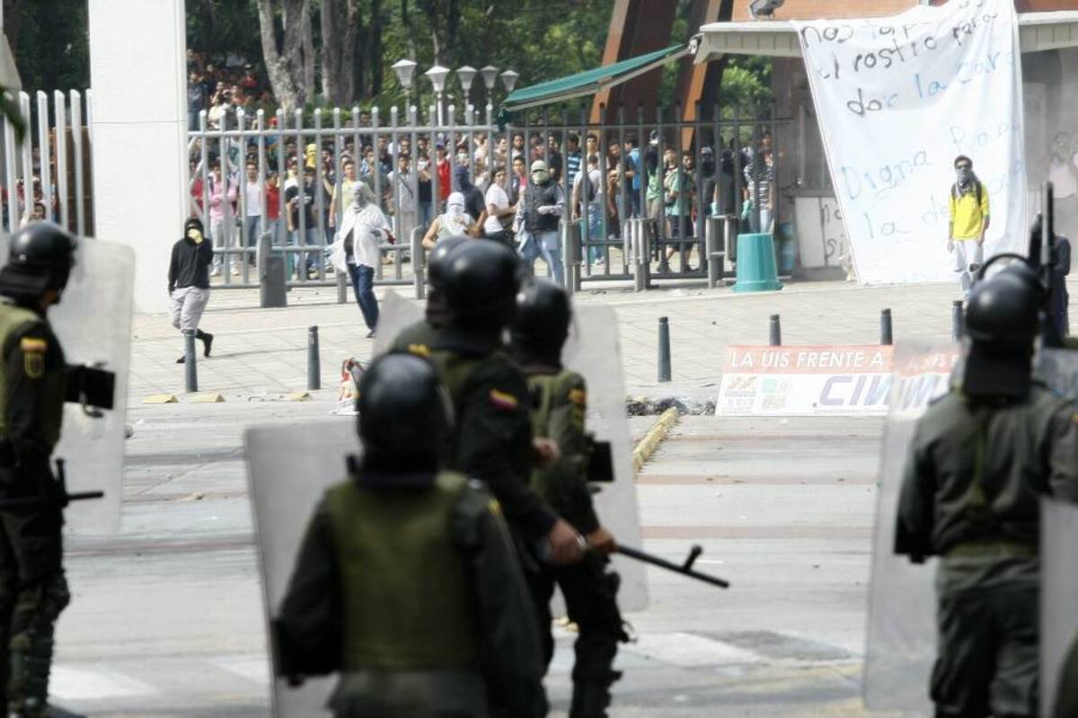 Mientras se enfrentaban encapuchados con uniformados de la Policía, algunos estudiantes quedaron sin poder salir de la UIS. (Foto: César Flórez/ VANGUARDIA LIBERAL)