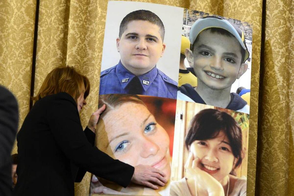 Una empleada descuelga un cartel con las fotos de las víctimas de los atentados de Boston, durante una audiencia del Comité de Seguridad Nacional celebrada ayer en el Capitolio en Washington. (Foto: AFP / VANGUARDIA)