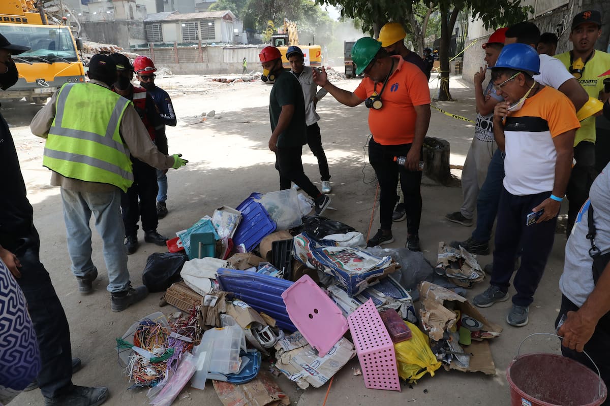 Personas observan pertenencias rescatadas en edificios afectados este miércoles, en Caracas (Venezuela).