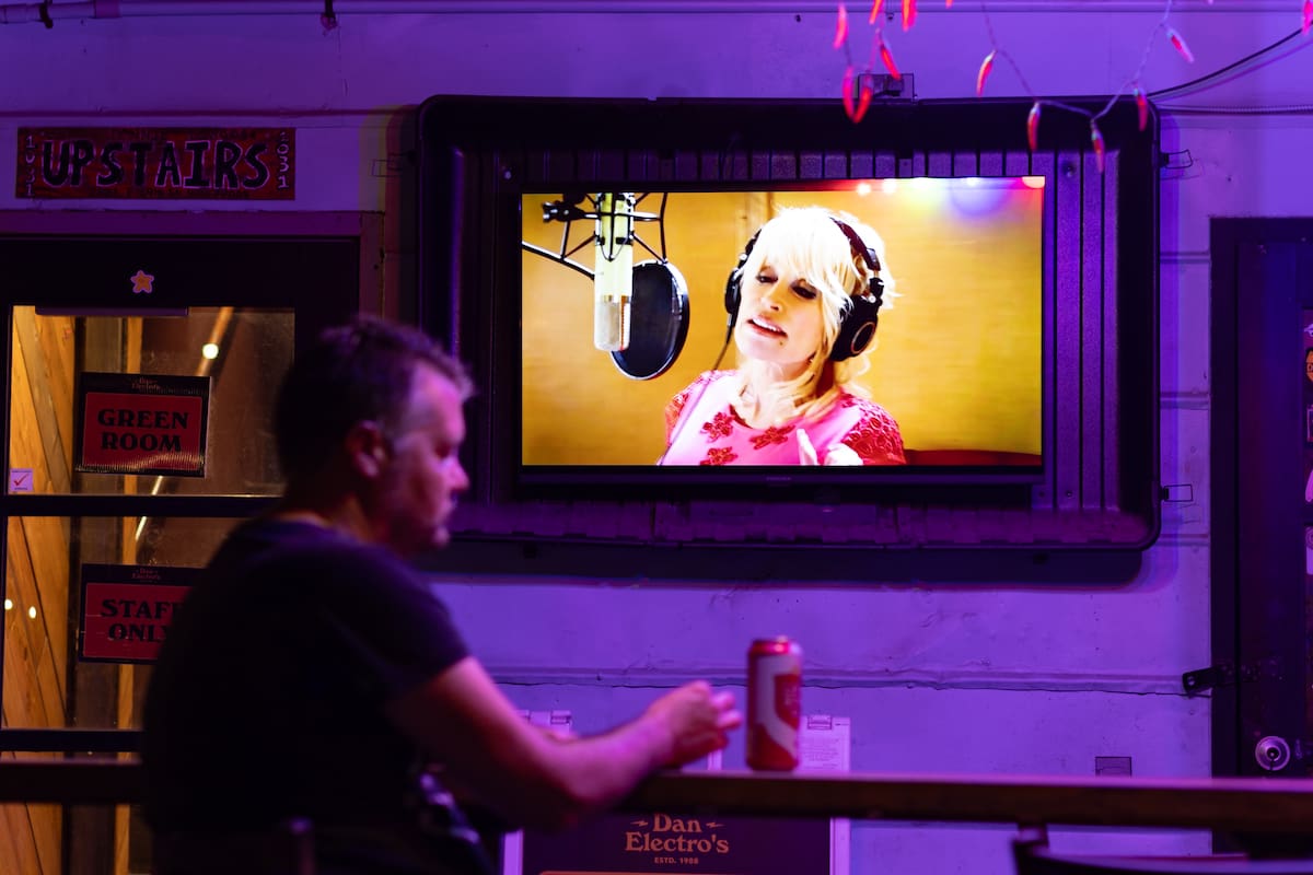 Una persona escucha música de la cantante Dolly Parton durante un homenaje este miércoles, en Dan Electro's Guitar Bar, en Houston (Estados Unidos). EFE/ Carlos Ramírez