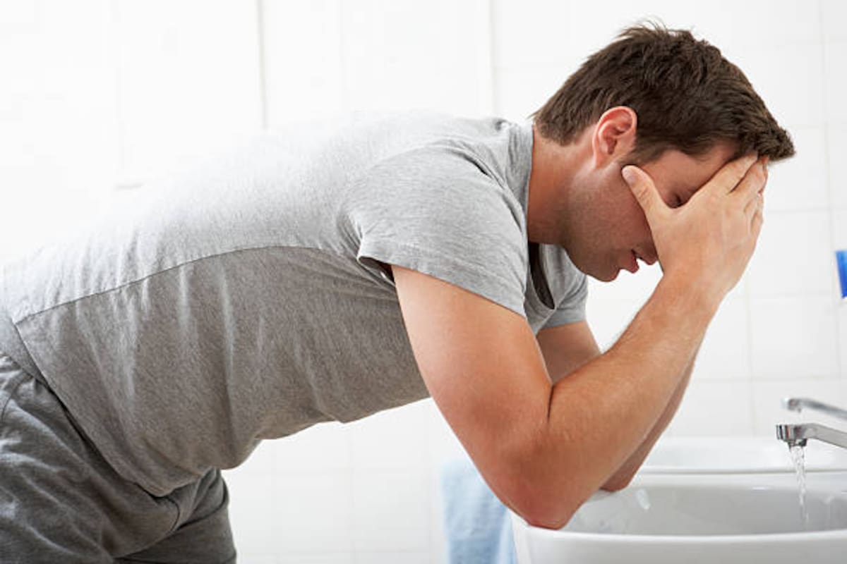 Un hombre sintiendo dolor en el baño.