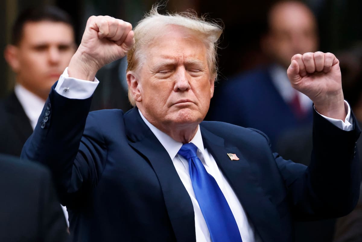 El presidente estadounidense Donald Trump hace gestos a los medios de comunicación.