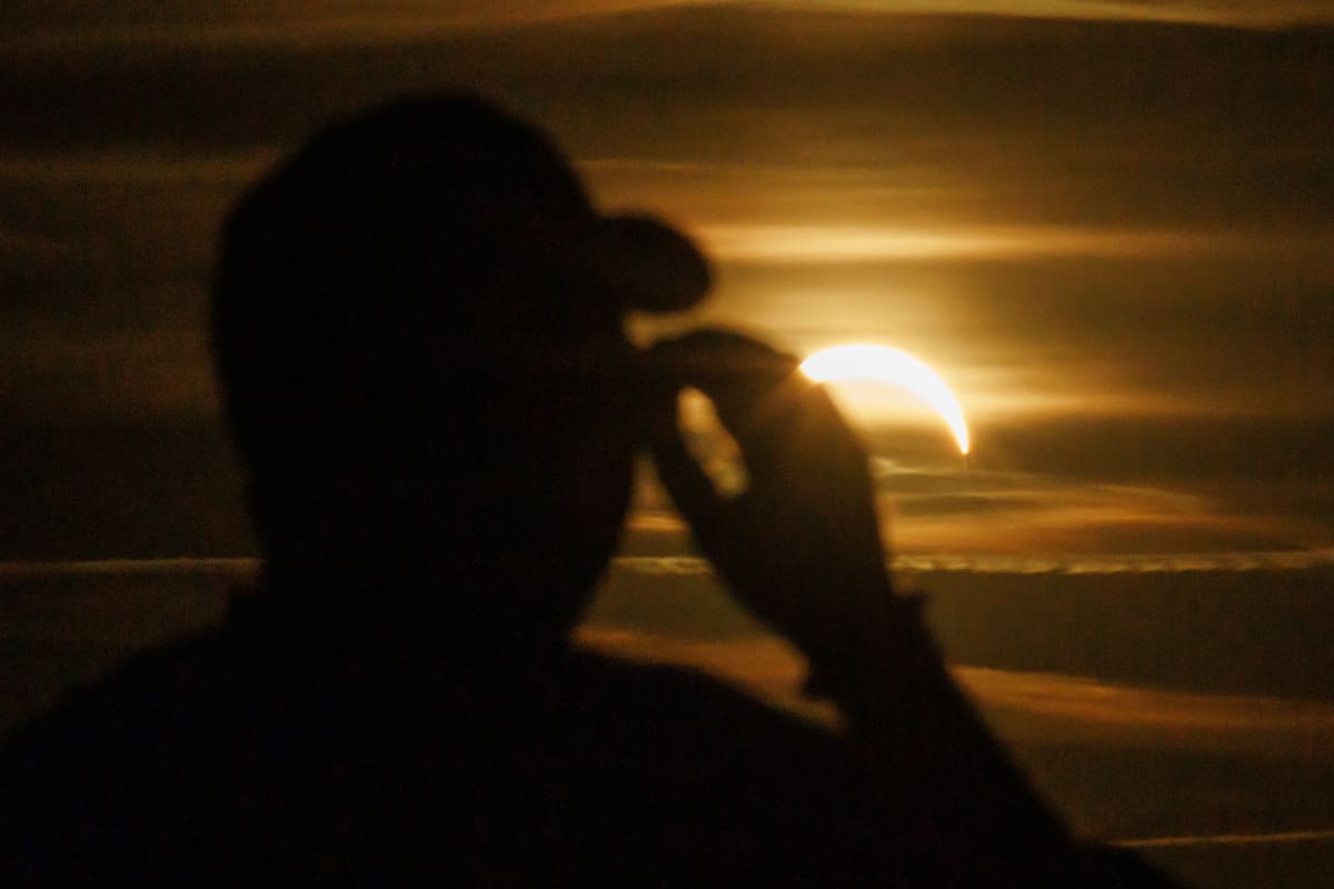 - Una persona se protege los ojos con gafas de protección mientras mira al sol durante un eclipse solar parcial en el parque Tempelhofer Feld de Berlín, Alemania, el 12 de agosto de 2026. (Alemania) EFE/EPA/CLEMENS BILAN