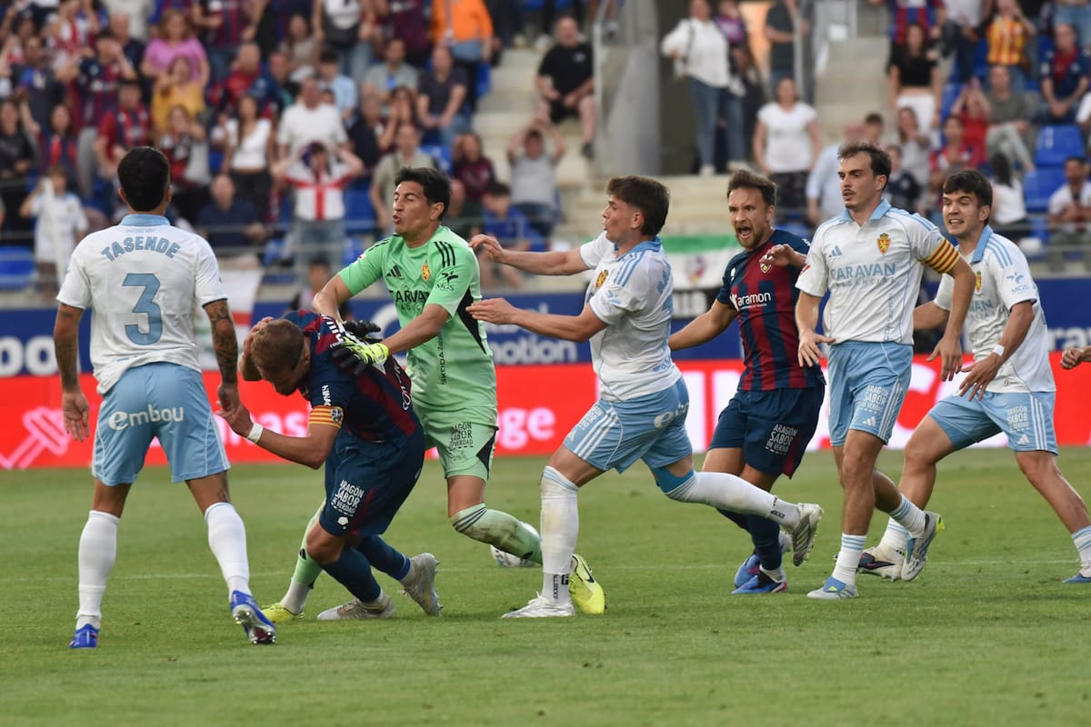 El argentino Esteban Andrada (3i), portero del Zaragoza, da un puñetazo al capitán del Huesca Jorge Pulido (2i) tras ser expulsado en el tiempo añadido del partido entre ambos equipos disputado ayer en la jornada 37 de LaLiga Hypermotion. EFE/Veronica Lacasa