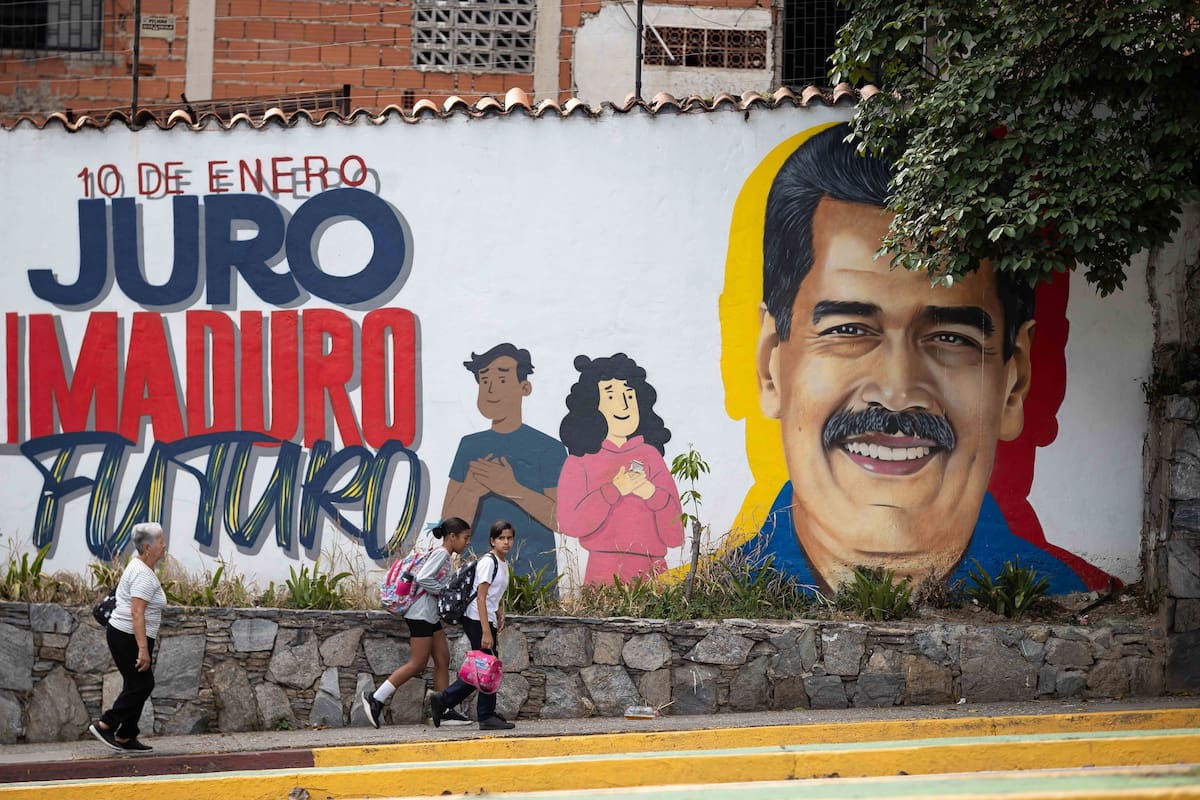 AME1285. CARACAS (VENEZUELA), 02/02/2026.- Fotografía que muestra a personas caminando frente a un mural del presidente de Venezuela, Nicolás Maduro, este lunes, en Caracas (Venezuela). El chavismo cumple 27 años en el poder de Venezuela con su actual líder, Nicolás Maduro, detenido en Estados Unidos, luego de que fuerzas de este país lo capturaran hace casi un mes junto a su esposa, la diputada Cilia Flores, en medio de una serie de ataques en suelo venezolano. EFE/ Ronald Peña R