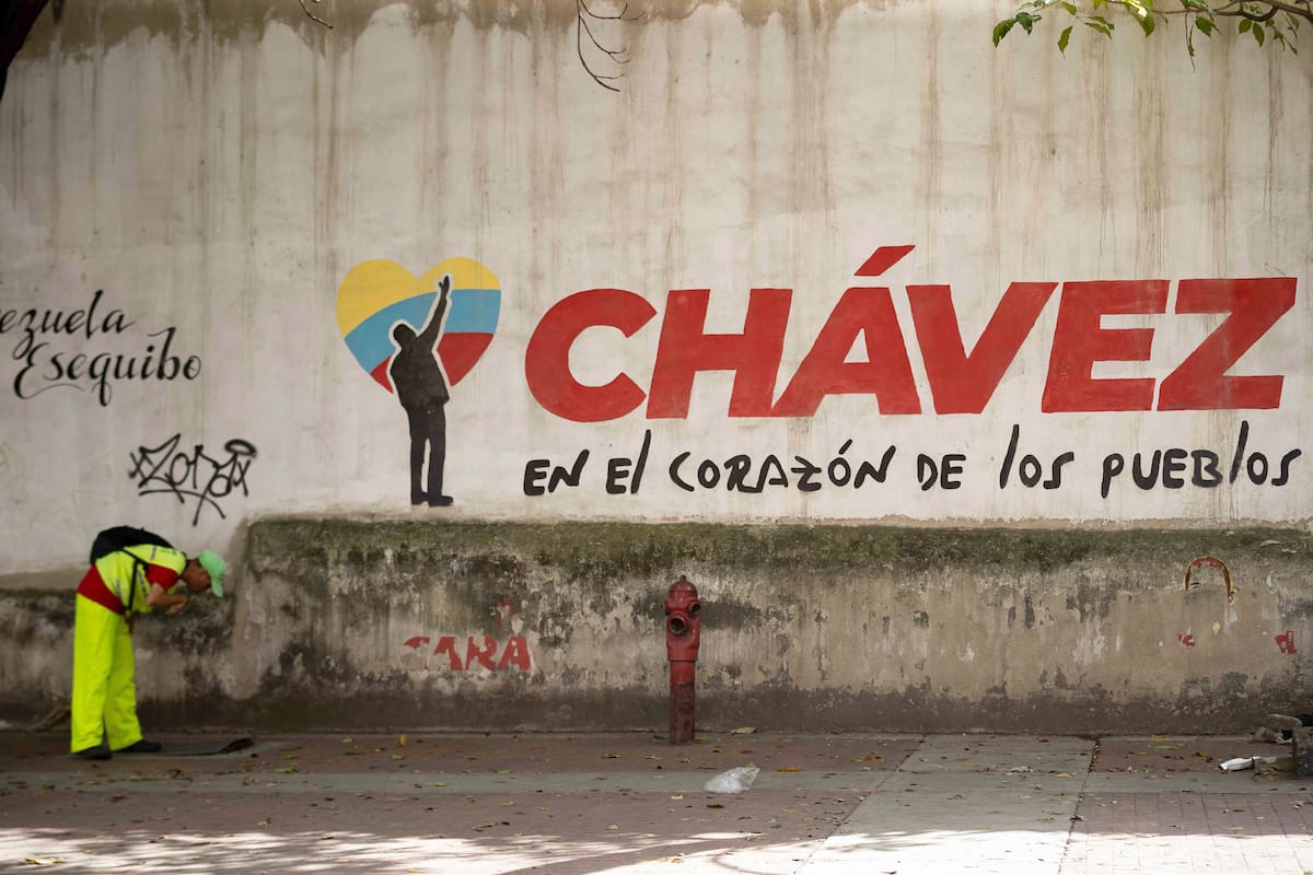 AME1285. CARACAS (VENEZUELA), 02/02/2026.- Un hombre camina frente a un mural alusivo al fallecido presidente de Venezuela, Hugo Chávez, este lunes, en Caracas (Venezuela). El chavismo cumple 27 años en el poder de Venezuela con su actual líder, Nicolás Maduro, detenido en Estados Unidos, luego de que fuerzas de este país lo capturaran hace casi un mes junto a su esposa, la diputada Cilia Flores, en medio de una serie de ataques en suelo venezolano. EFE/ Ronald Peña R