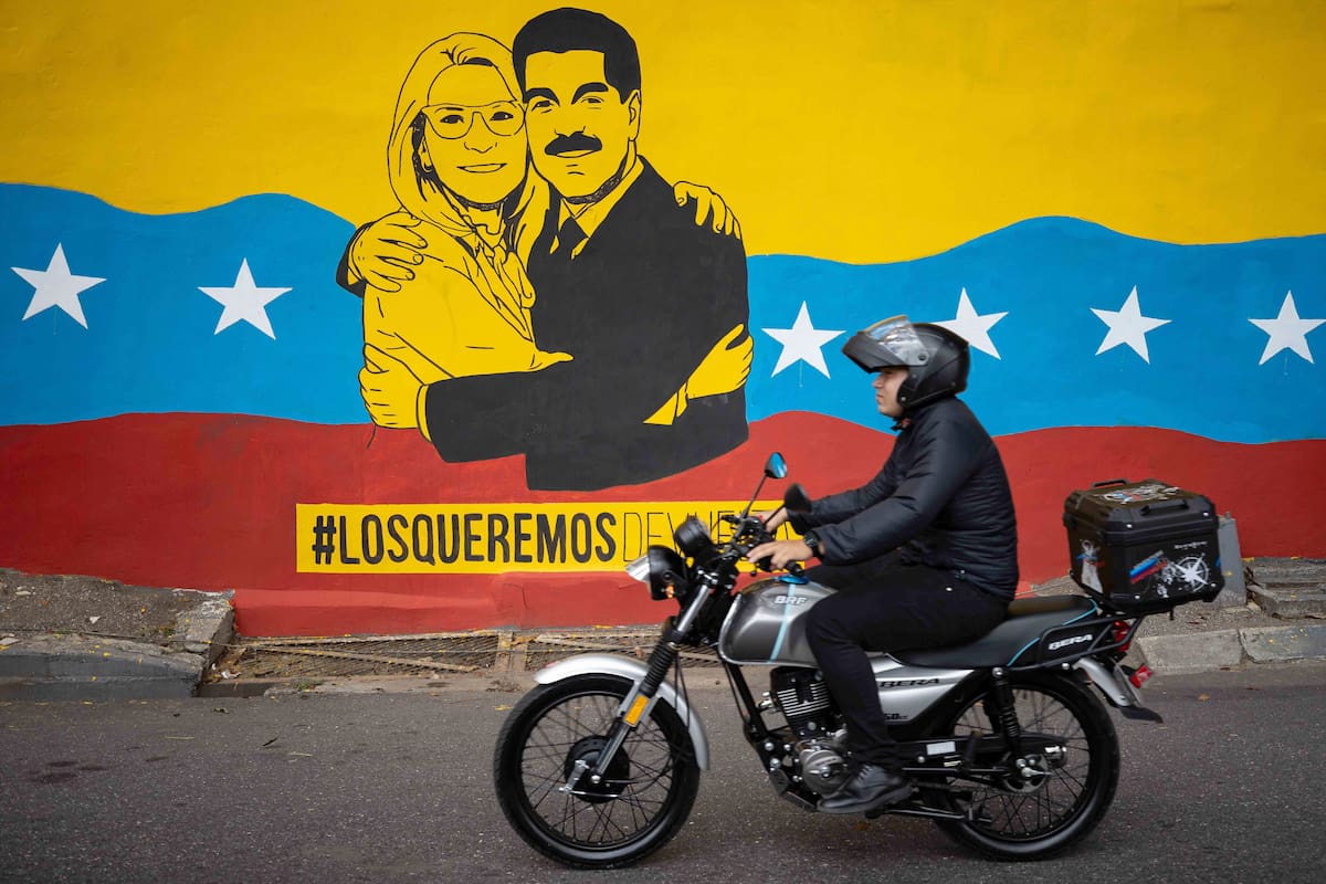 AME1285. CARACAS (VENEZUELA), 02/02/2026.- Una persona transita frente a un mural del presidente de Venezuela, Nicolás Maduro, y su esposa, Cilia Flores, este lunes, en Caracas (Venezuela). El chavismo cumple 27 años en el poder de Venezuela con su actual líder, Nicolás Maduro, detenido en Estados Unidos, luego de que fuerzas de este país lo capturaran hace casi un mes junto a su esposa, la diputada Cilia Flores, en medio de una serie de ataques en suelo venezolano. EFE/ Ronald Peña R