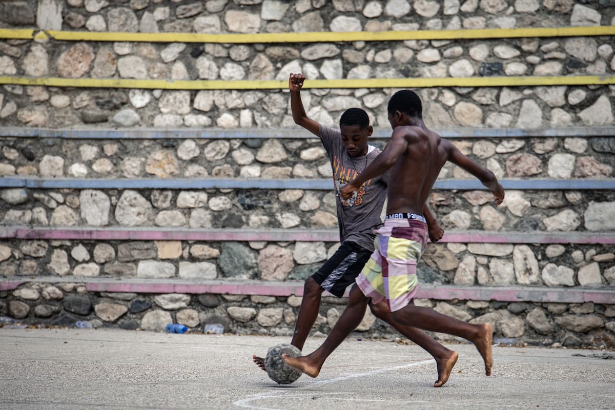 ACOMPAÑA CRÓNICA: HAITÍ FÚTBOL MUNDIAL 2026 AME6963. PUERTO PRÍNCIPE (HAITÍ), 13/12/2025.- Fotografía del 28 de noviembre de 2025 que muestra a personas jugando fútbol, en Puerto Príncipe (Haití). A pesar de la falta de infraestructuras y de un marco legal adecuado, con la capital tomada por las bandas armadas, el fútbol sigue siendo un deporte muy practicado y seguido en Haití, que se ha visto reforzado por la reciente clasificación del país para la Copa del Mundo tras medio siglo de ausencia. EFE/ Mentor David Lorens