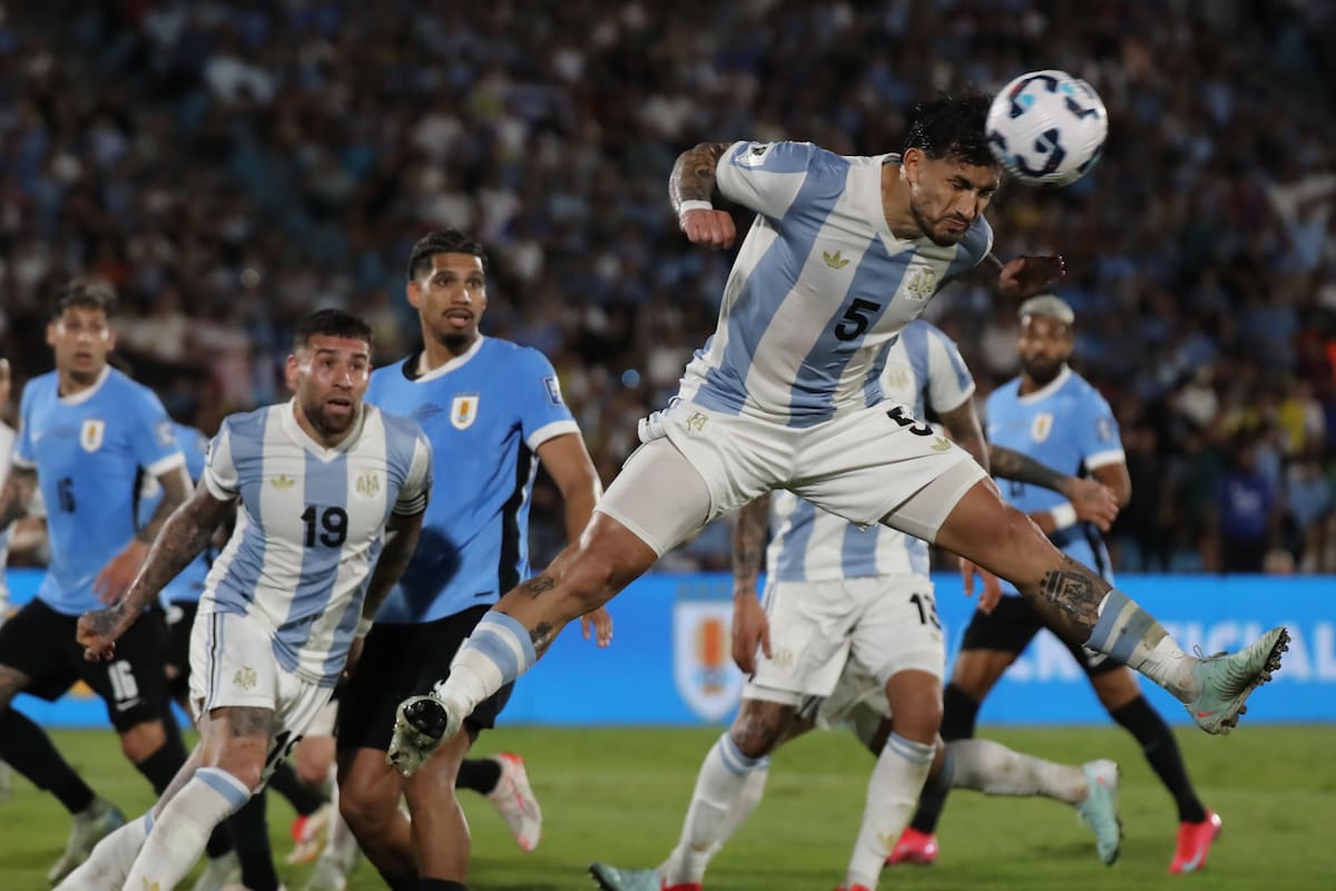 Leandro Paredes (d) de Argentina despeja un balón este viernes, en un partido de las eliminatorias sudamericanas para el Mundial de 2026 entre las selecciones de Uruguay y Argentina en el estadio Centenario en Montevideo (Uruguay). EFE/ Raúl Martínez