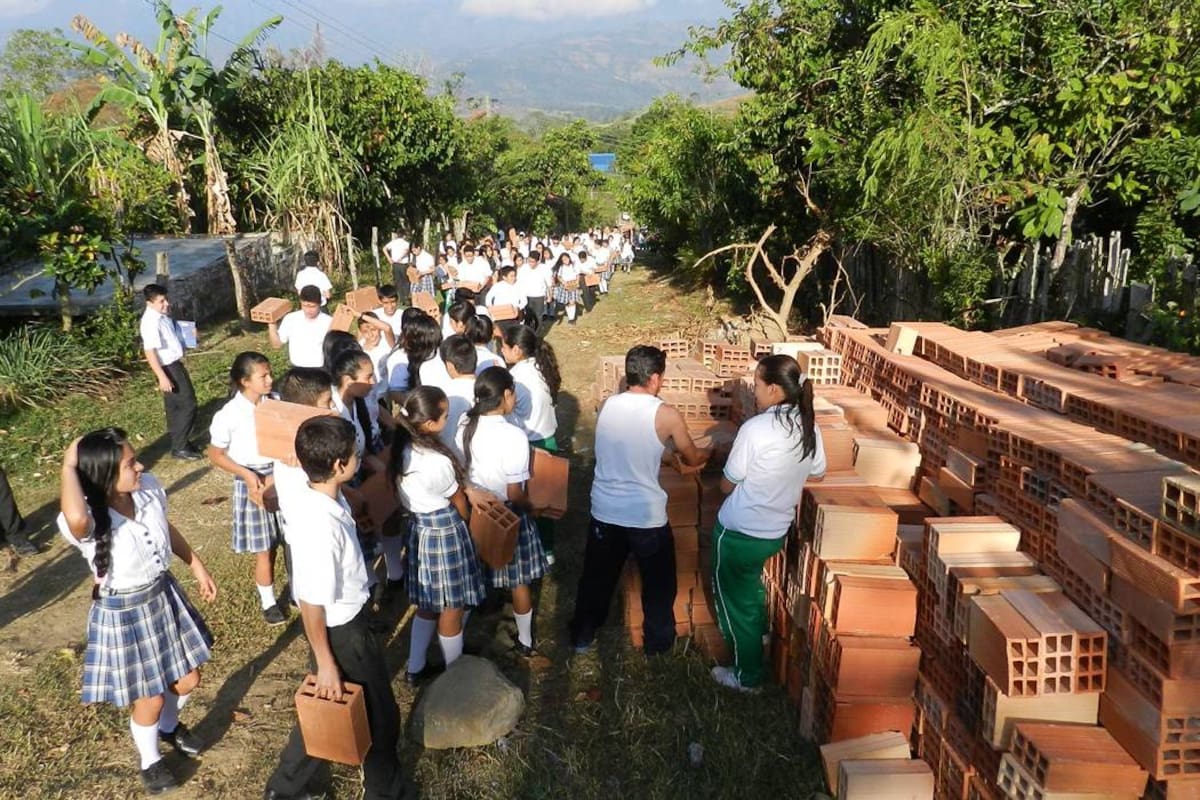 Gran cantidad de estudiantes del Colegio “Manuela Beltrán” de Guapotá participaron de la marcha del ladrillo, liderada por el párroco Mario Aparicio Blanco, para construir una vivienda. (Foto: Luis Fernando Martínez Vargas/VANGUARDIA LIBERAL)