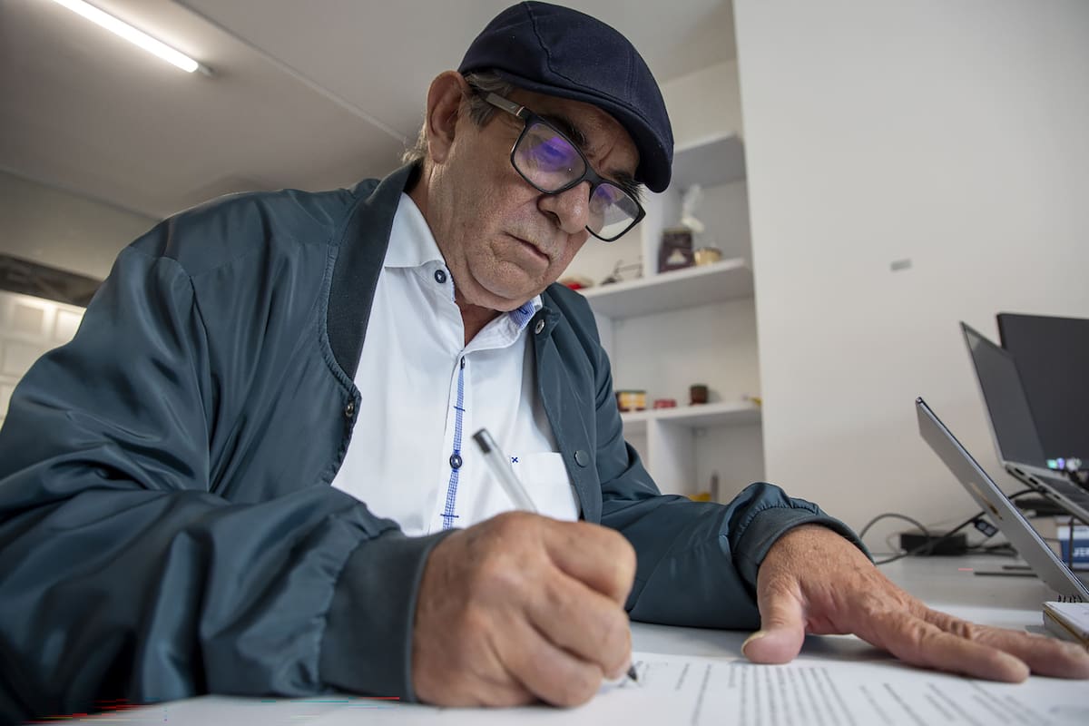 Rodrigo Londoño, conocido como Timochenko, firmando un documento en las instalaciones de la JEP. // Foto: EFE/ Jurisdicción Especial para la Paz