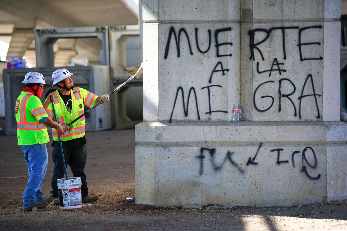 AME9456. AUSTIN (ESTADOS UNIDOS), 21/09/2026.- Personas cubren con pintura un grafitti este lunes, en el lugar en donde un agente del Servicio de Inmigración y Control de Aduanas (ICE, en inglés) disparó por la espalda a un migrante venezolano, que resultó gravemente herido, en Austin (Estados Unidos). EFE/ Carlos Ramírez