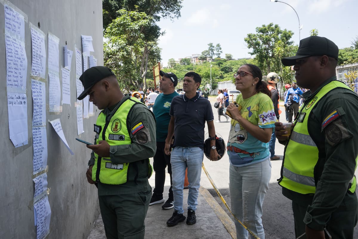 AME4889. CARACAS (VENEZUELA), 26/06/2026.- Integrantes de la Policía revisan una lista de heridos y fallecidos este viernes, en Caracas (Venezuela). Familiares recorren distintos hospitales para intentar ubicar a sus parientes heridos o fallecidos tras los terremotos de 7,2 y 7,5 registrados la tarde del miércoles y que han dejado, hasta el momento, 920 personas muertas. EFE/ Boris Vergara