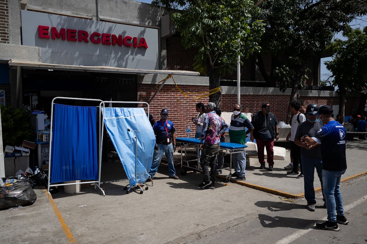 AME4867. CATIA LA MAR (VENEZUELA), 26/06/2026.- Personas aguardan este viernes, frente a un centro de emergencia en Catia La Mar (Venezuela). Familiares recorren distintos hospitales para intentar ubicar a sus parientes heridos o fallecidos tras los terremotos de 7,2 y 7,5 registrados la tarde del miércoles y que ha dejado, hasta el momento, un saldo de 920 personas muertas. EFE/ Ronald Peña R