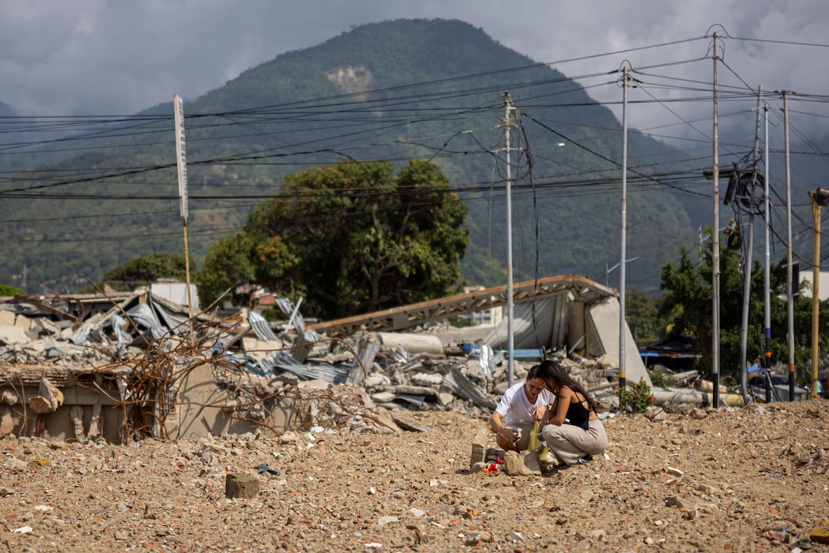 Rosbel González y Julio Carrillo hacen un altar en el terreno donde se encontraba el edificio Solymar, lugar donde murieron familiares en el doble terremoto del 24 de junio, este lunes, en Caraballeda (Venezuela). EFE/ Miguel Gutiérrez