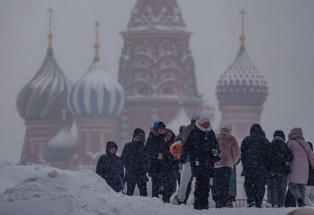 Personas caminan en la Plaza Roja durante una fuerte nevada en Moscú, Rusia,este viernes.