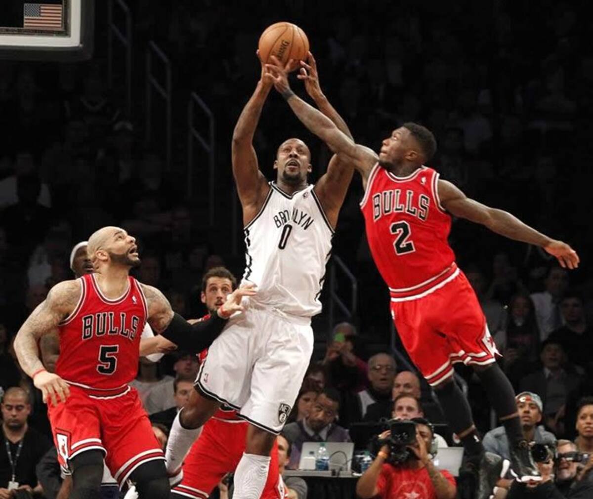 El jugador de Nets Andray Blatche agarra el balón ante la marca de Nate Robinson y Carlos Boozer de Bulls. (Foto: Efe/VanguardiaLiberal)