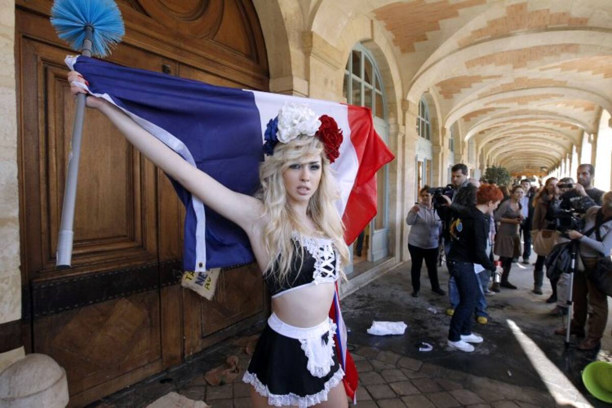 Una femme exhibe la bandera francesa en frente de la casa de Strauss-Kahn. (Foto: AFP)