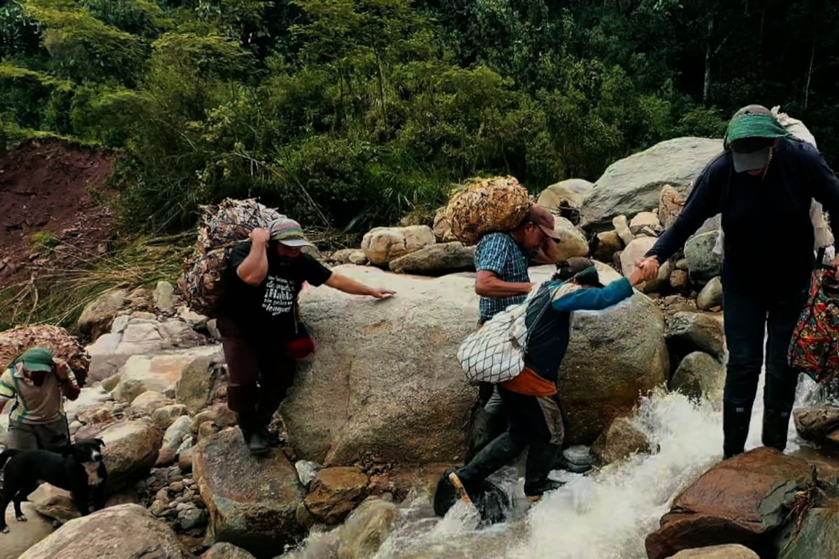 Las familias arriesgan sus vidas pasando entre las piedras y el agua.