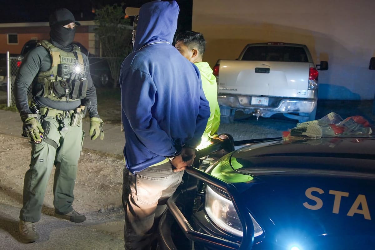 Fotografía cedida por el Servicio de Control de Inmigración (ICE) donde aparece un agente de la Policía durante el arresto de dos indocumentados en Florida (Estados Unidos). EFE / VANGUARDIA