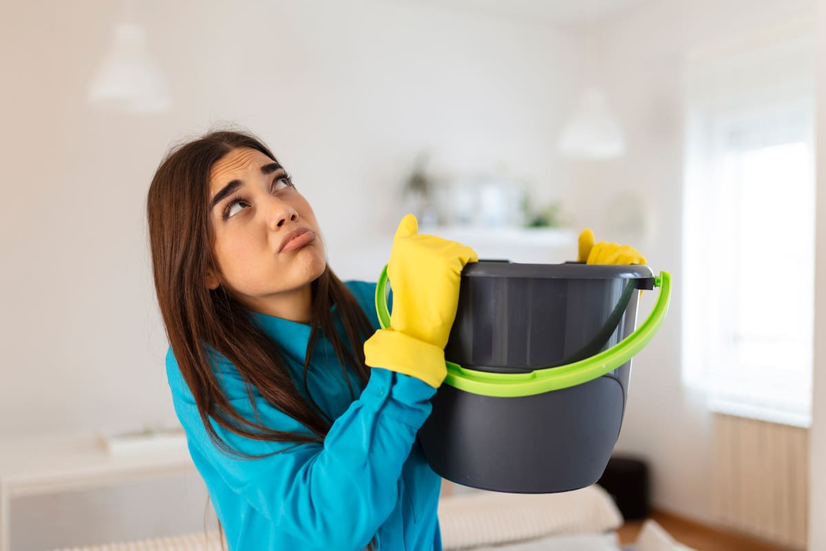 Una mujer lidiando con una gotera en su casa. Freepik / VANGUARDIA