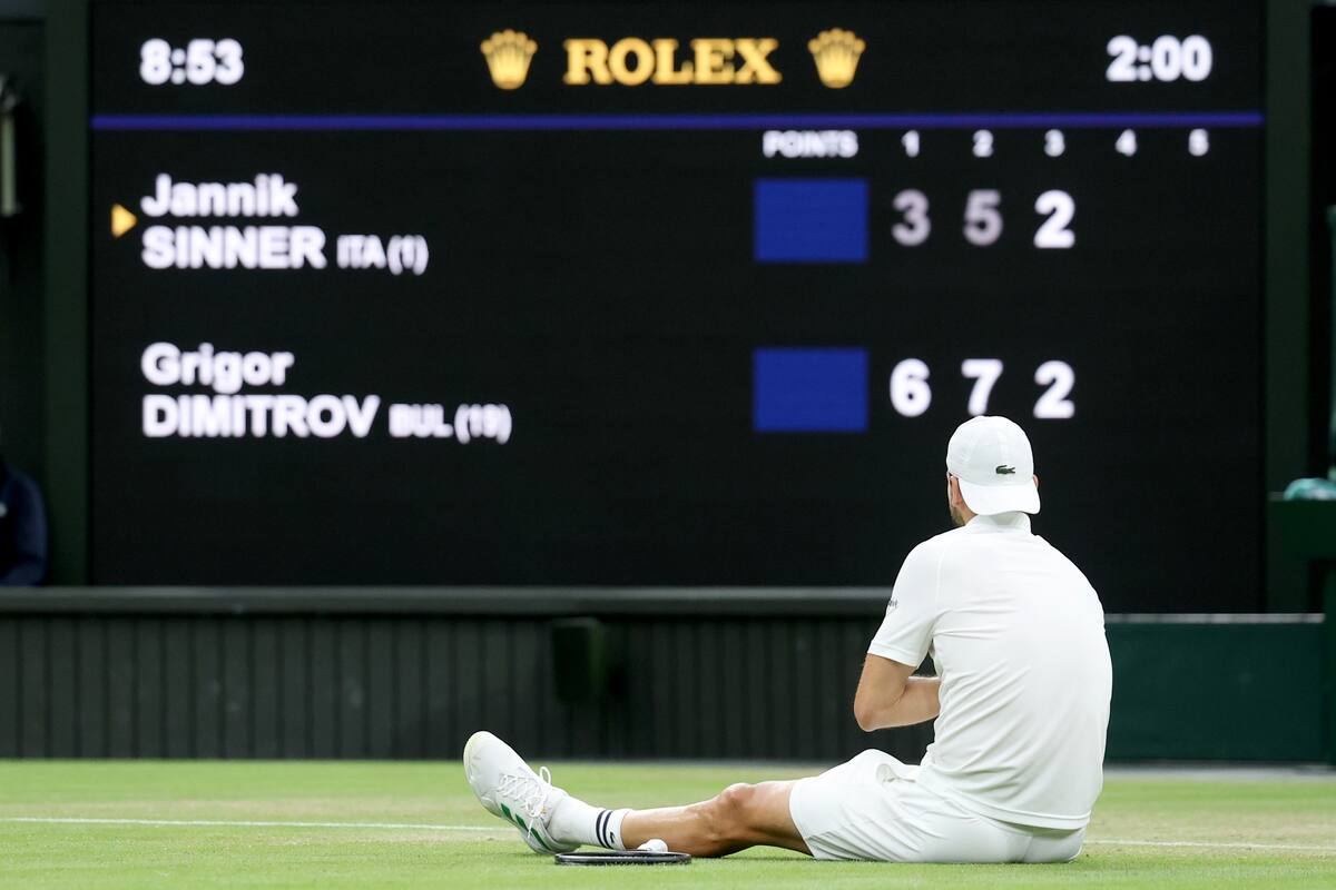 Grigor Dimitrov de Bulgaria se sienta en el suelo después de una lesión durante su partido de octavos de final individual masculino contra Jannik Sinner de Italia en el Campeonato de Wimbledon. //Foto, EFE: NEIL HALL