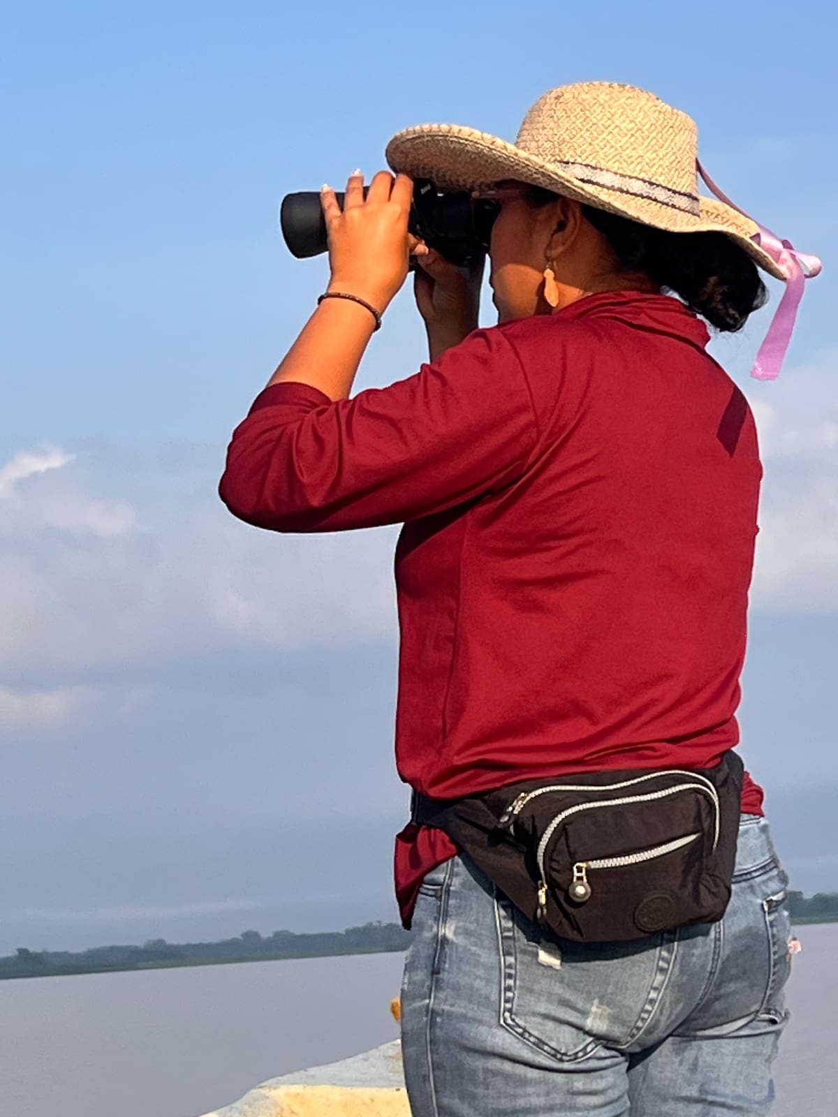 Yelisa Potes, hija de un pescador y líder reconocida de la zona, quien a través de unos binoculares busca el rastro del manatí (Fotos de Lesly Cifuentes / VANGUARDIA).