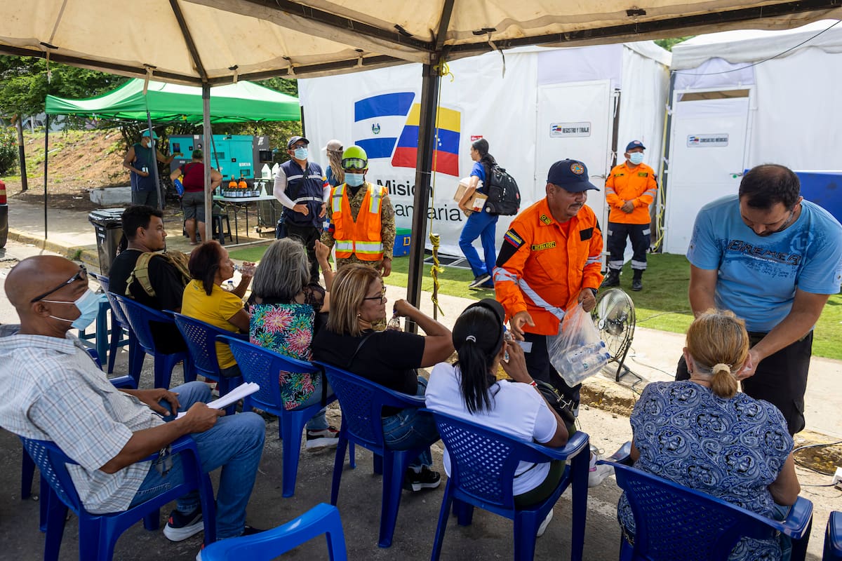 AMDEP8640. CATIA LA MAR (VENEZUELA), 14/07/2026.- Personas esperan ser atendidas este lunes, en el hospital de campaña de El Salvador en Catia La Mar (Venezuela). La búsqueda entre los escombros tras el potente doble terremoto en Venezuela ha dejado también víctimas colaterales que han acudido a varios de los 14 hospitales de campaña internacionales instalados en Caracas y la devastada región costera de La Guaira, aledaña a la capital. EFE/ Miguel Gutiérrez