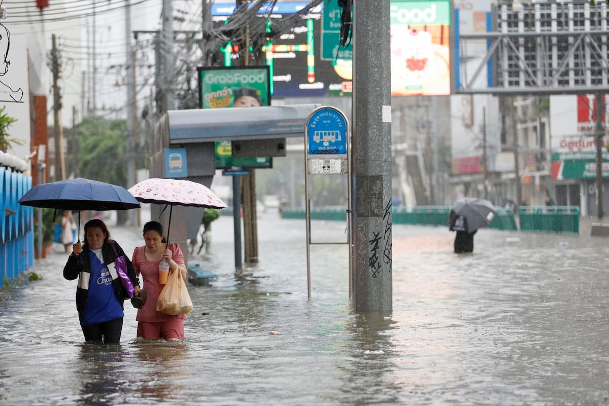 Residentes caminan entre el agua durante un aguacero en la calle Phetchaburi de Bangkok, cuyos 50 distritos han sido declarados zona de desastre por inundaciones tras las persistentes y fuertes lluvias provocadas por un intenso sistema de baja presión, sumado a los patrones estacionales del monzón. EFE/EPA/RUNGROJ YONGRIT