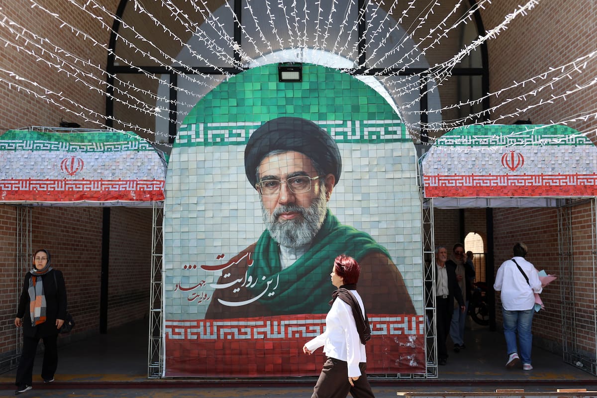 Iraníes caminan junto a una imagen del líder supremo de Irán, el ayatolá Mojtaba Jamenei, en una calle de Teherán. //EFE/EPA/ABEDIN TAHERKENAREH.