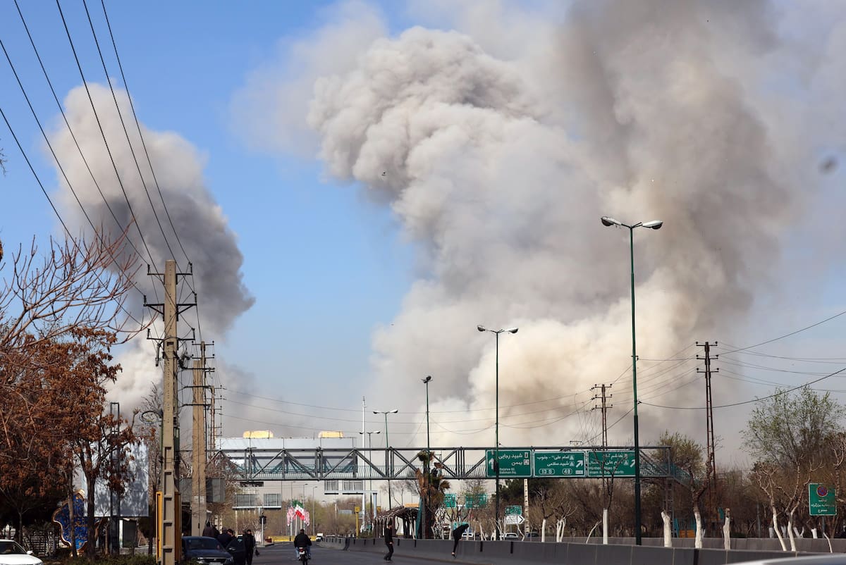 La gente corre en busca de refugio mientras el humo se eleva tras un ataque aéreo en el centro de Teherán, Irán, este jueves. Una operación militar conjunta israelí-estadounidense continúa atacando múltiples puntos de Irán desde la madrugada del 28 de febrero de 2026. EFE/ Abedin Taherkenareh