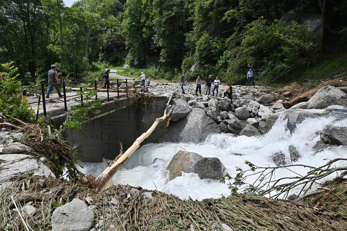 Varias personas miran una zona dañada por las inundaciones en Chialamberto, Valle de Lanzo, cerca de Turín, Italia, 30 de junio de 2024. EFE //