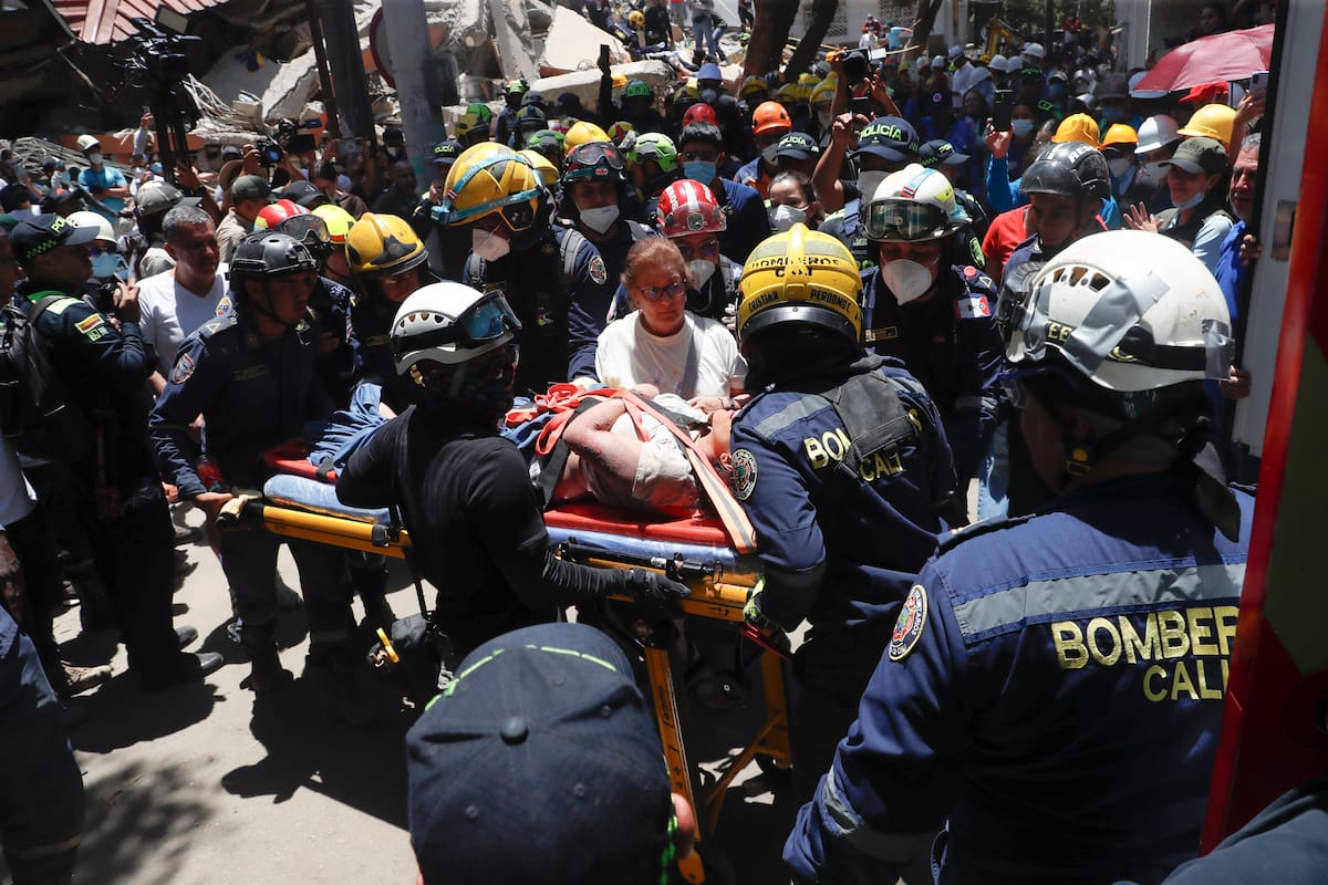AME8083. CALI (COLOMBIA), 11/08/2026.- Integrantes del cuerpo de Bomberos de Cali rescatan a Diana Troncoso (c) entre los escombros que dejó el terremoto de magnitud 7,4, este martes en Torres del Limonar, en Cali (Colombia). EFE/ Ernesto Guzmán