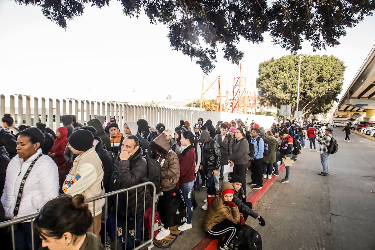 MEX333. TIJUANA (MÉXICO), 20/01/2025.- Migrantes permanecen varados este lunes, en el puerto fronterizo de El Chaparral, en Tijuana (México). Cientos de migrantes quedaron varados después de que el gobierno del nuevo presidente, Donald Trump, cancelara el programa CBP-One, que permitía a migrantes solicitar citas para pedir asilo en EE.UU. a través de los puertos de entrada en la frontera con México. EFE/ Joebeth Terríquez