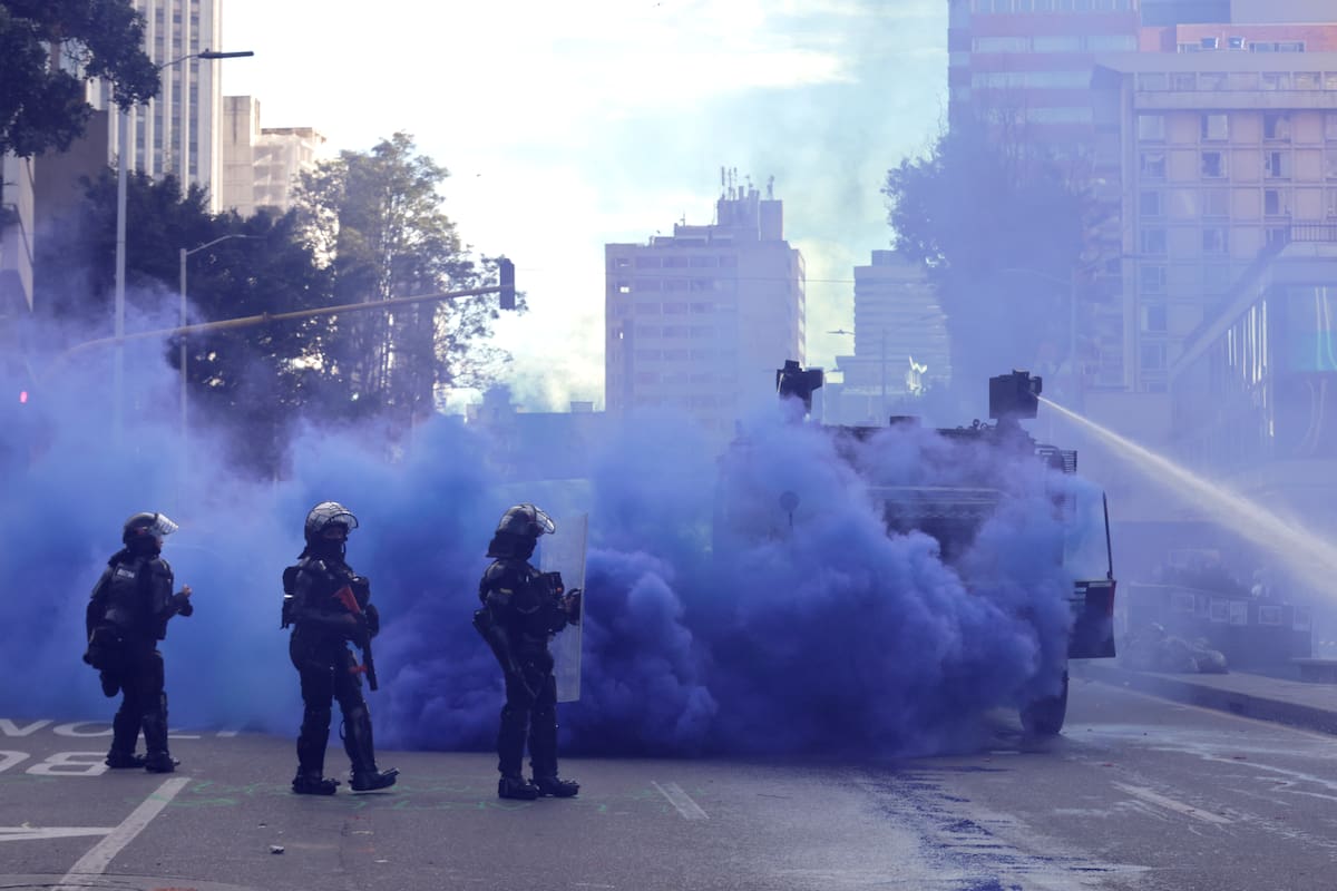 Integrantes de la Unidad Nacional de Antidisturbios (Unadi) se enfrentan a manifestantes frente al Museo Nacional durante una protesta por el retiro de al menos 30 piezas relacionadas con los movimientos feministas y LGBTI, las víctimas de la violencia política y el acuerdo de paz firmado en 2016 con las FARC, este domingo en Bogotá (Colombia). EFE/ Carlos Ortega