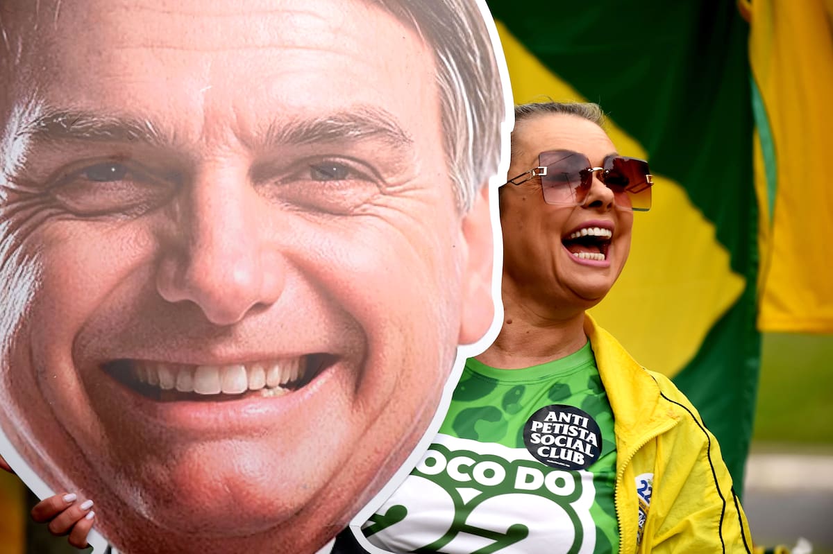 Una simpatizante del candidato a la presidencia de Brasil, Flávio Bolsonaro, sostiene una imagen del expresidente de Brasil Jair Bolsonaro este domingo, en Porto Alegre (Brasil). La segunda vuelta de las elecciones presidenciales en Brasil transcurre con normalidad, en una jornada pasada por agua en varias regiones del país en la que los ciudadanos decidirán entre Luiz Inácio Lula da Silva y Flávio Bolsonaro al próximo jefe de Estado. EFE/ Ricardo Rímoli