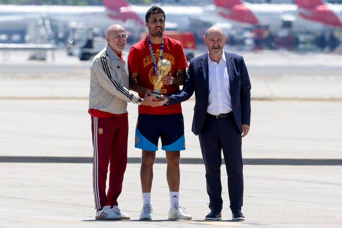 El capitán de la selección española de fútbol, Rodri (c), que lleva el trofeo de la Copa del Mundo, acompañado del seleccionador nacional, Luis de la Fuente (i), y el presidente de la RFEF, Rafael Louzán, a su llegada al aeropuerto de Madrid Barajas después de proclamarse anoche campeona del Mundial en Estados Unidos tras vencer a Argentina en la final. EFE/ J.J.Guillen