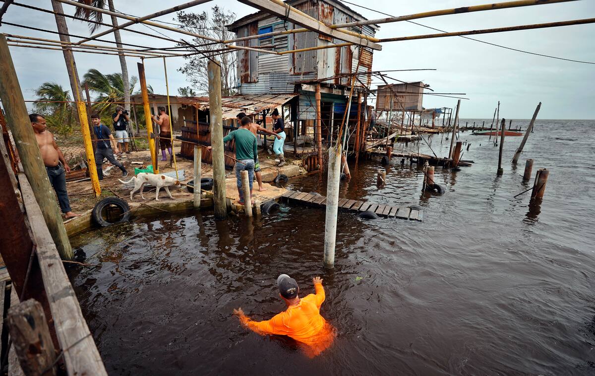 Un pescador nada en el agua tras el paso del huracán Rafael, en Playa Majana, en la provincia de Artemisa (Cuba), en una imagen de archivo. EFE/ VANGUARDIA
