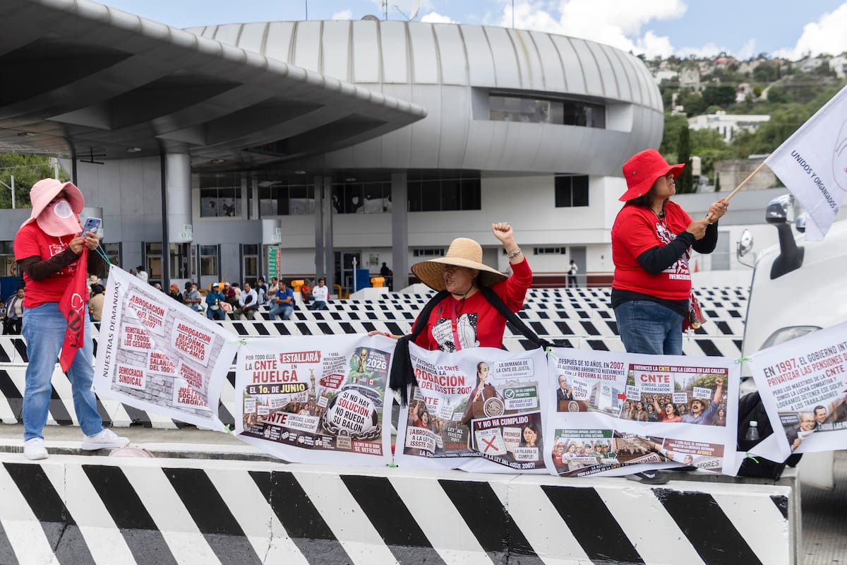 MEX5960. CIUDAD DE MÉXICO (MÉXICO), 15/06/2026.- Personas sostienen banderas durante una protesta en el peaje México-Cuernavaca este lunes, en Ciudad de México (México). La Coordinadora Nacional de Trabajadores de la Educación (CNTE) exigió una postura formal a la presidenta de México, Claudia Sheinbaum, tras sus declaraciones en las que amagó con suspender la interlocución con el magisterio disidente debido a las recientes protestas masivas durante la celebración de la Copa Mundial 2026. EFE/ Madla Hartz