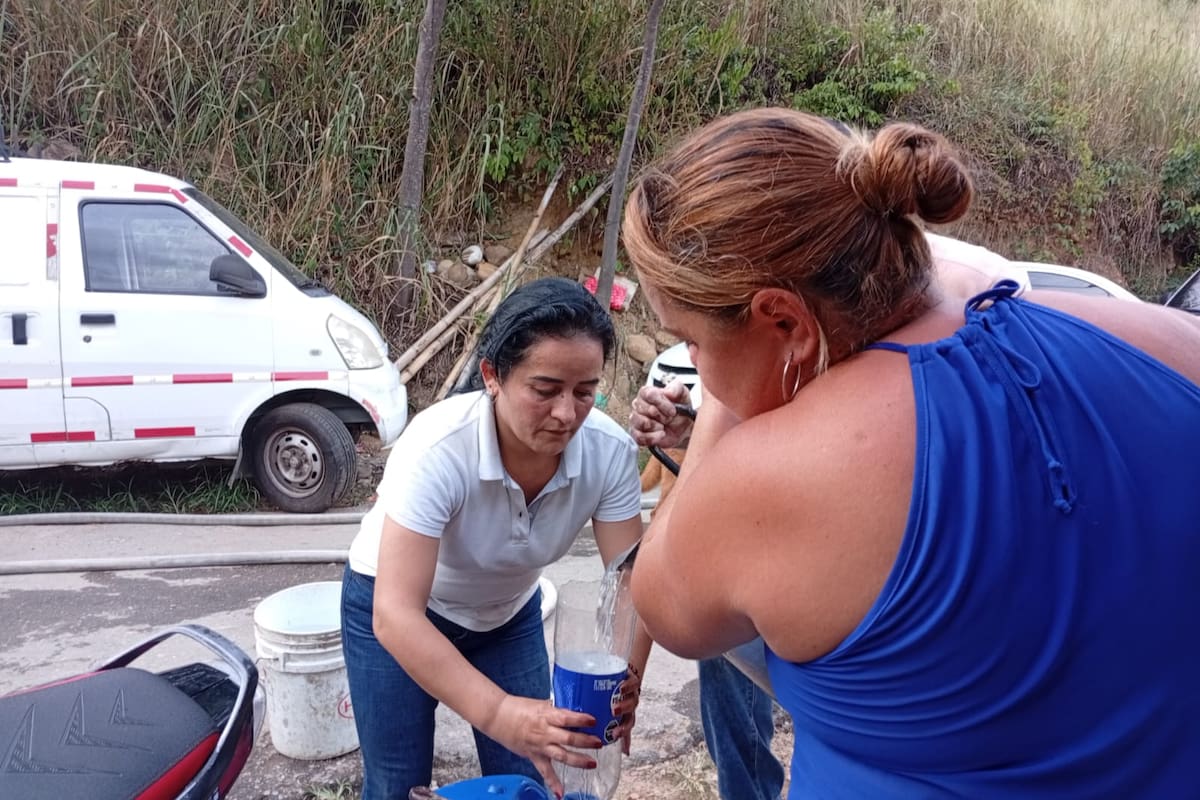 Habitantes del asentamiento Luz de Salvación 2 recolectan agua en recipientes tras varios días de desabastecimiento en uno de los sectores más poblados del barrio.
